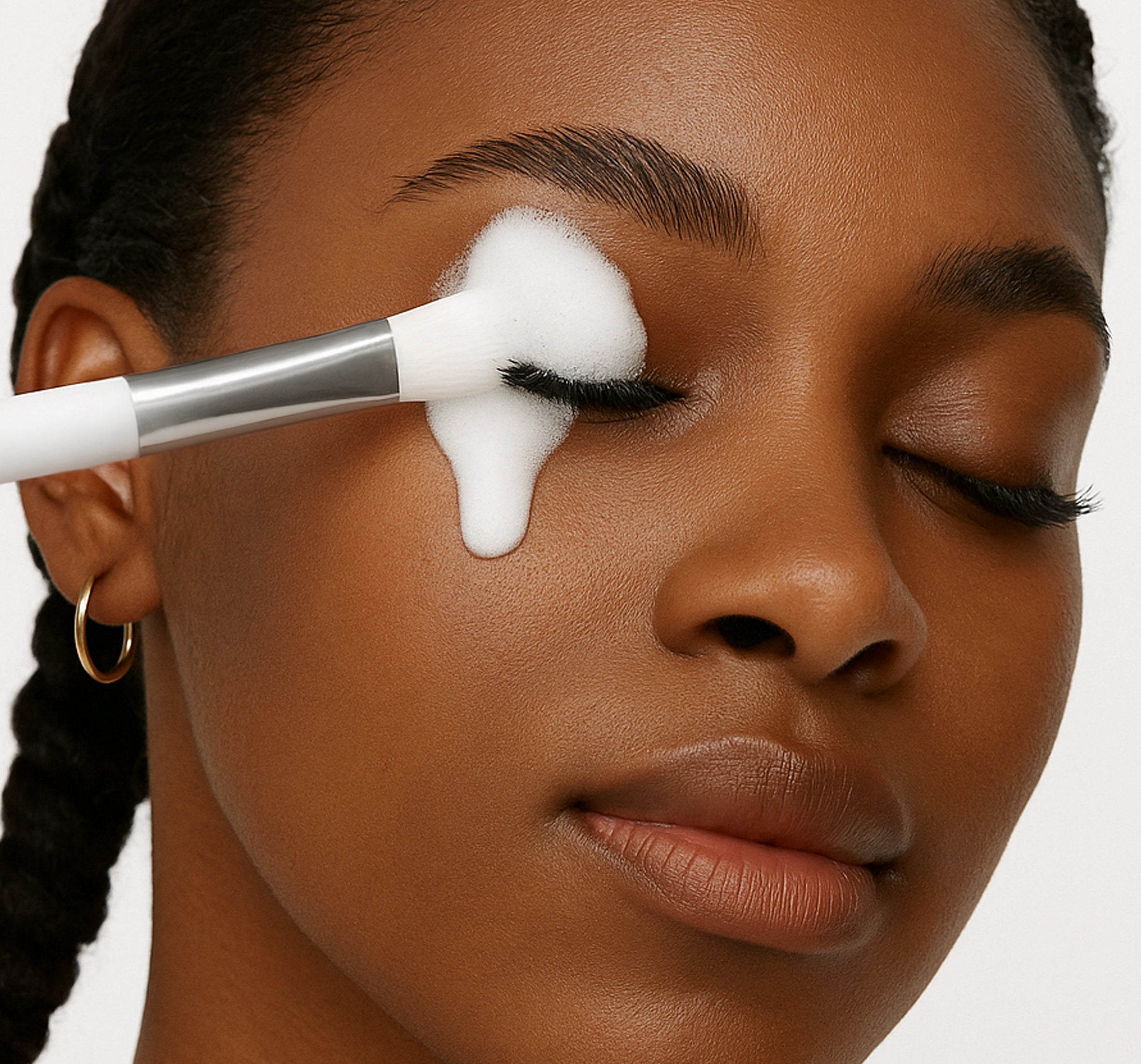 a woman cleaning her lashes with Stacy Lash Shampoo