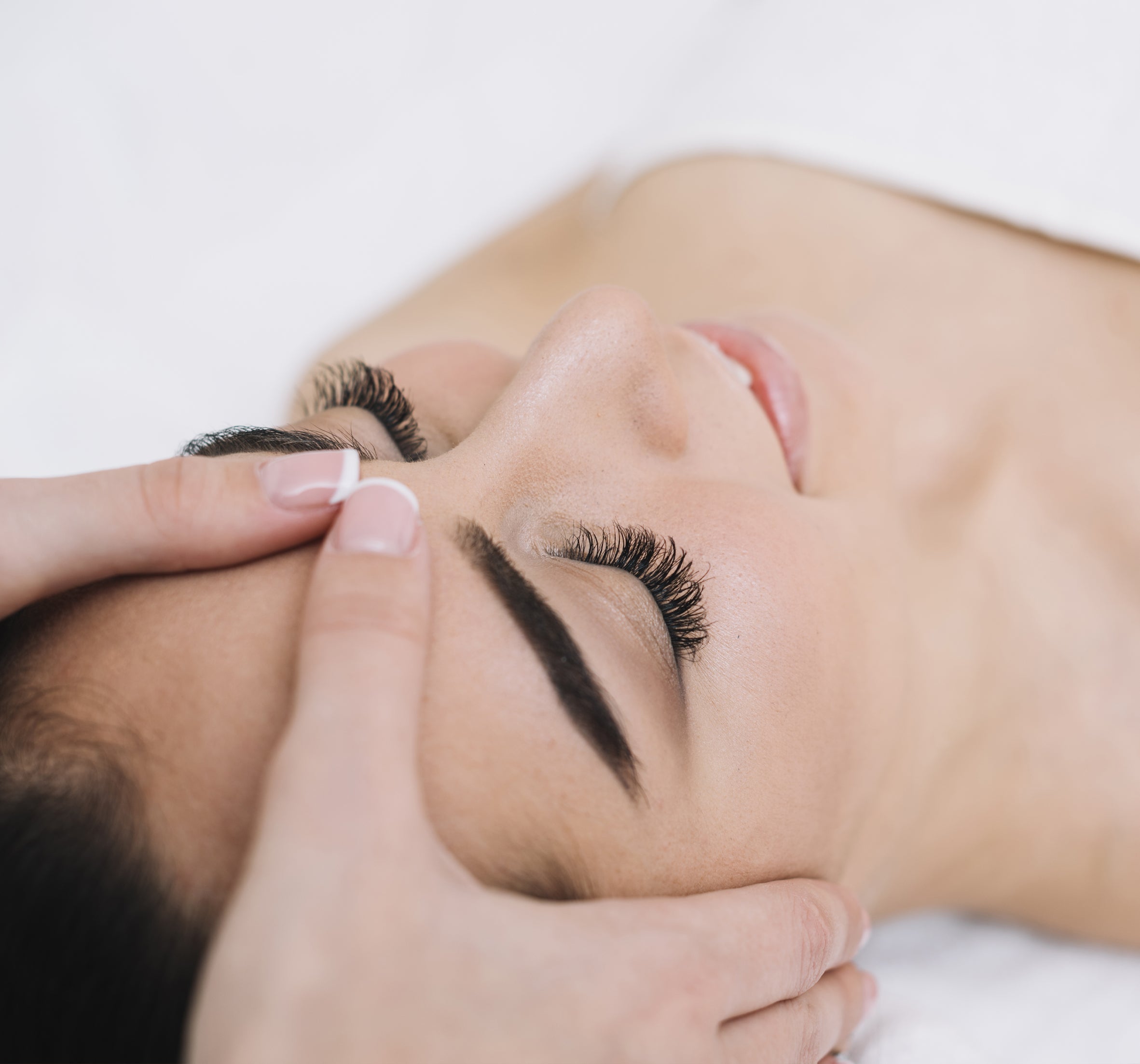 Lash tech gently holding the client's head