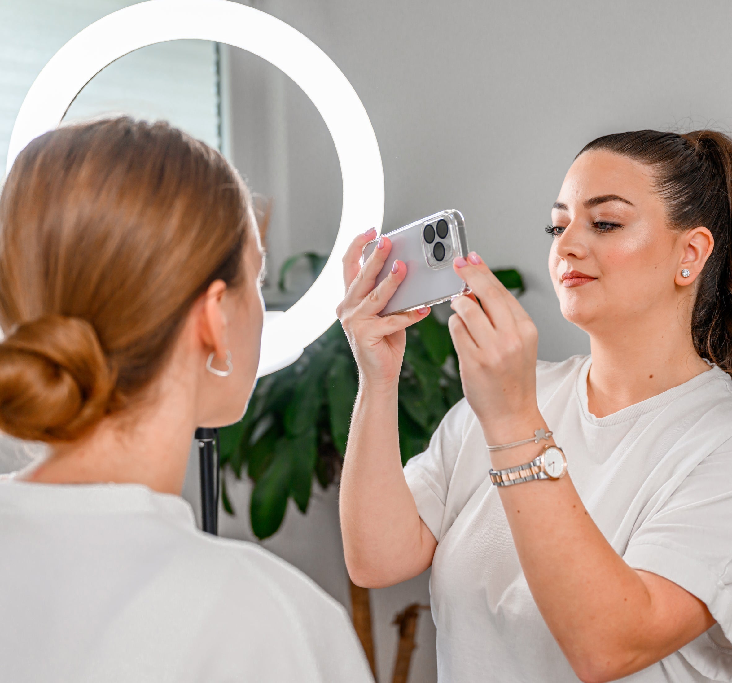 a lash artist taking a photo of her client