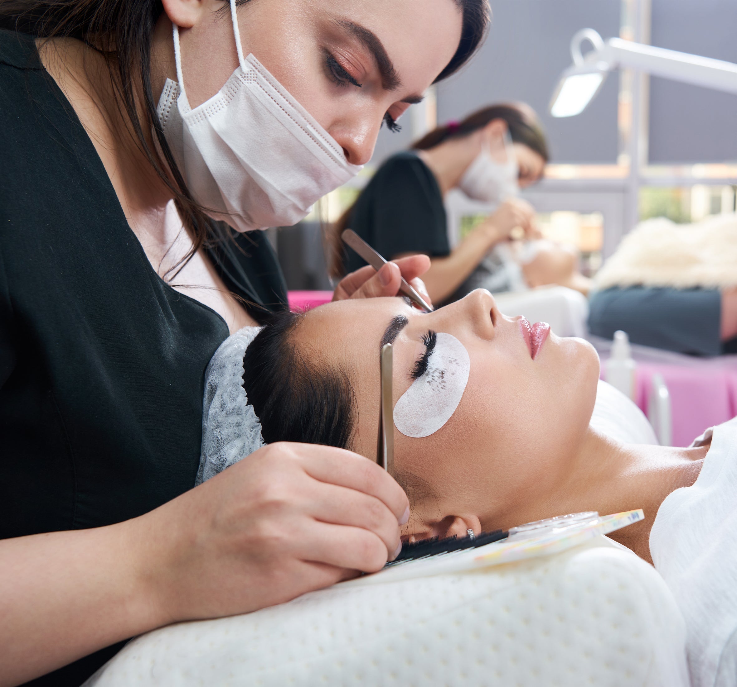 Professional lash artist applying eyelash extensions