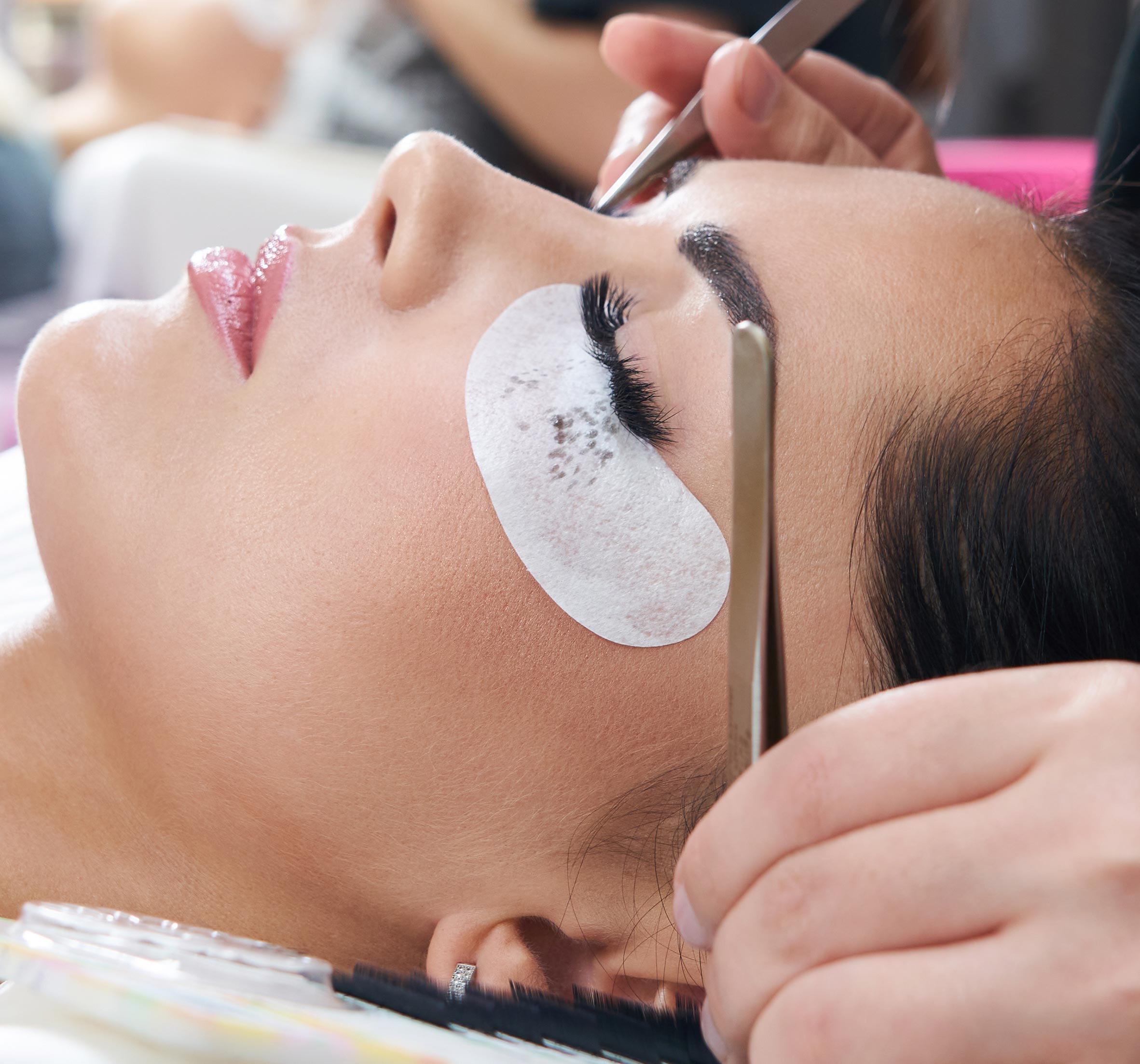 Professional lash artist applying eyelash extensions