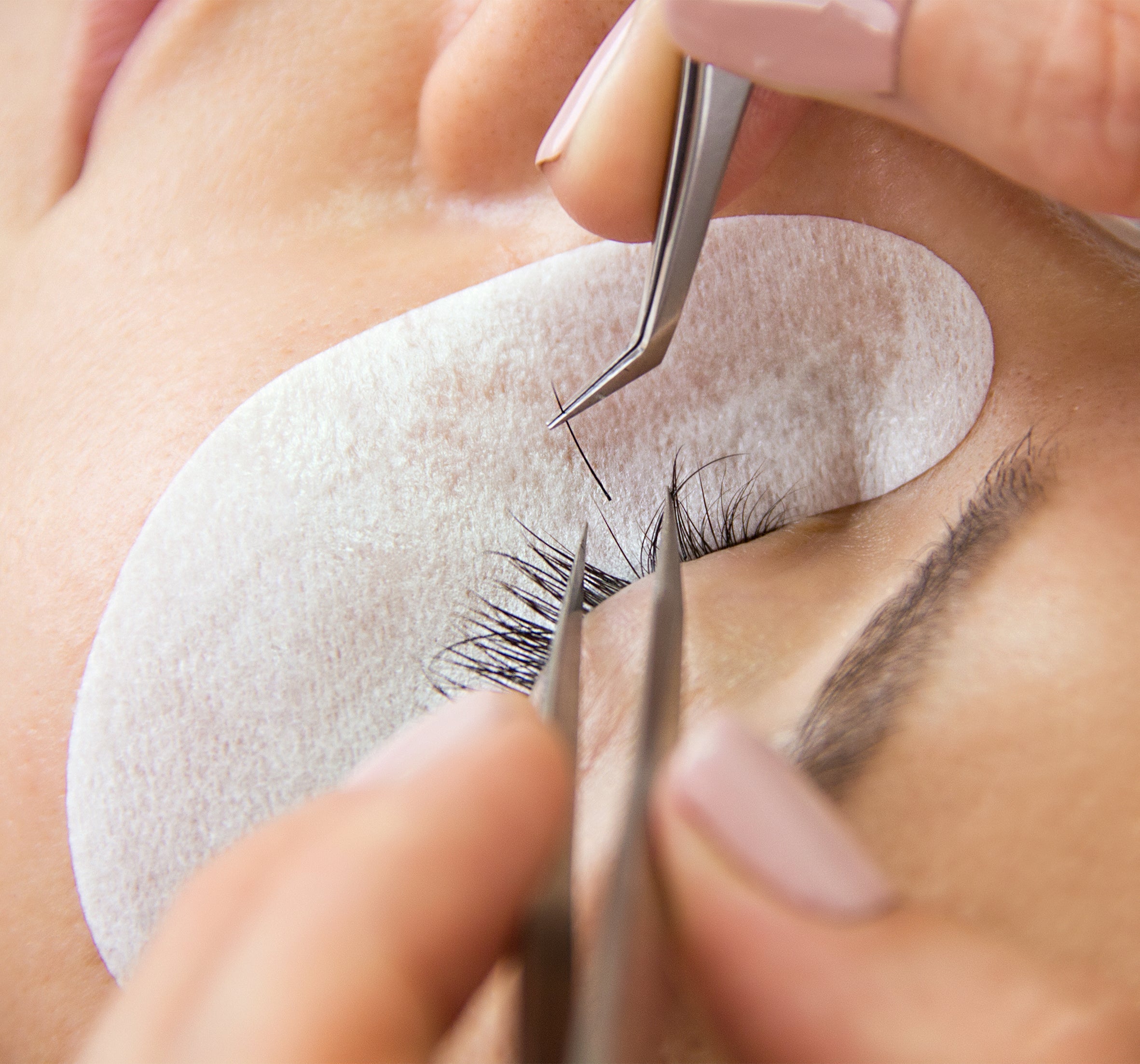 closeup of an eye while applying classic extensions