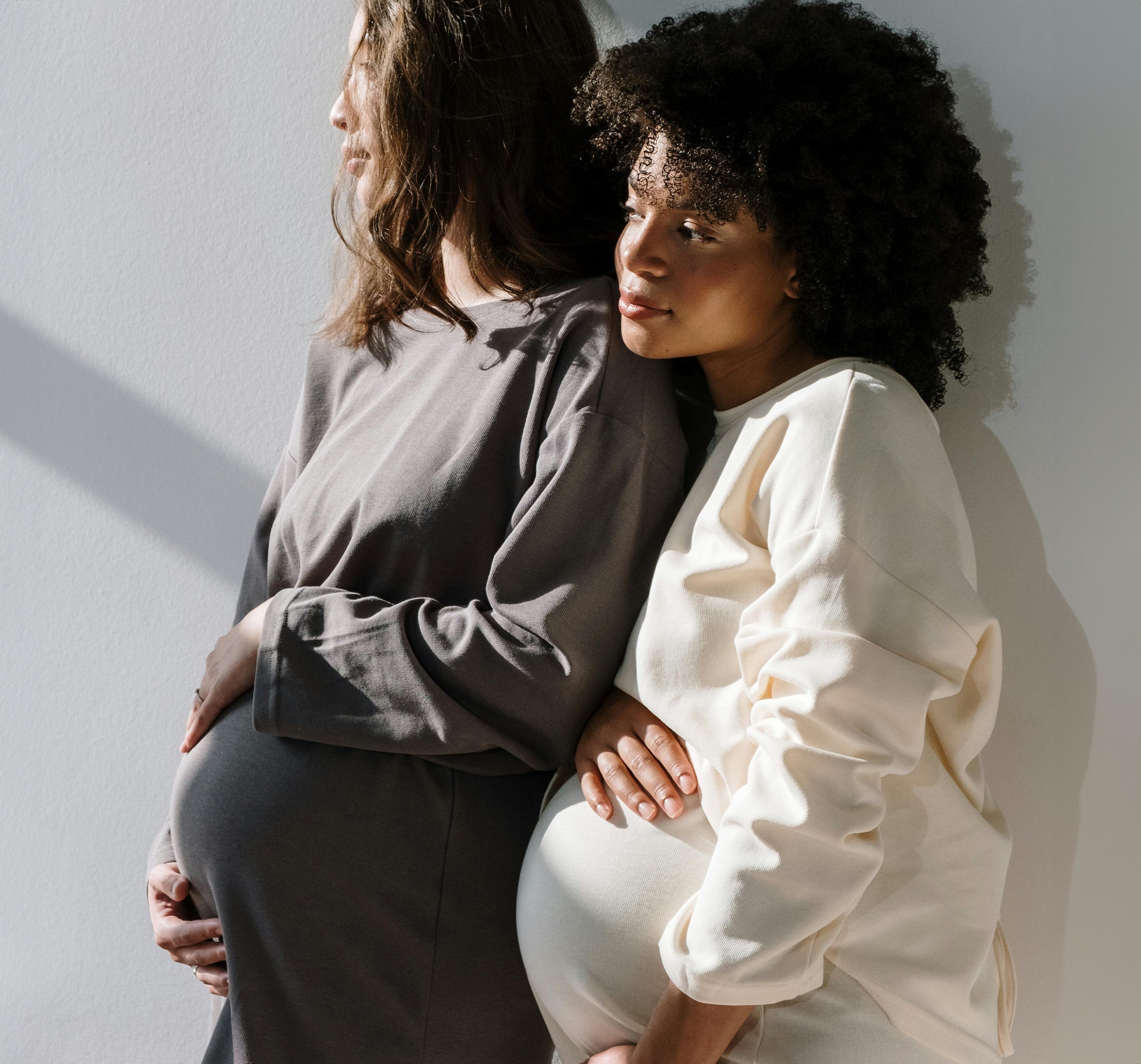 two pregnant women standing and thinking something over