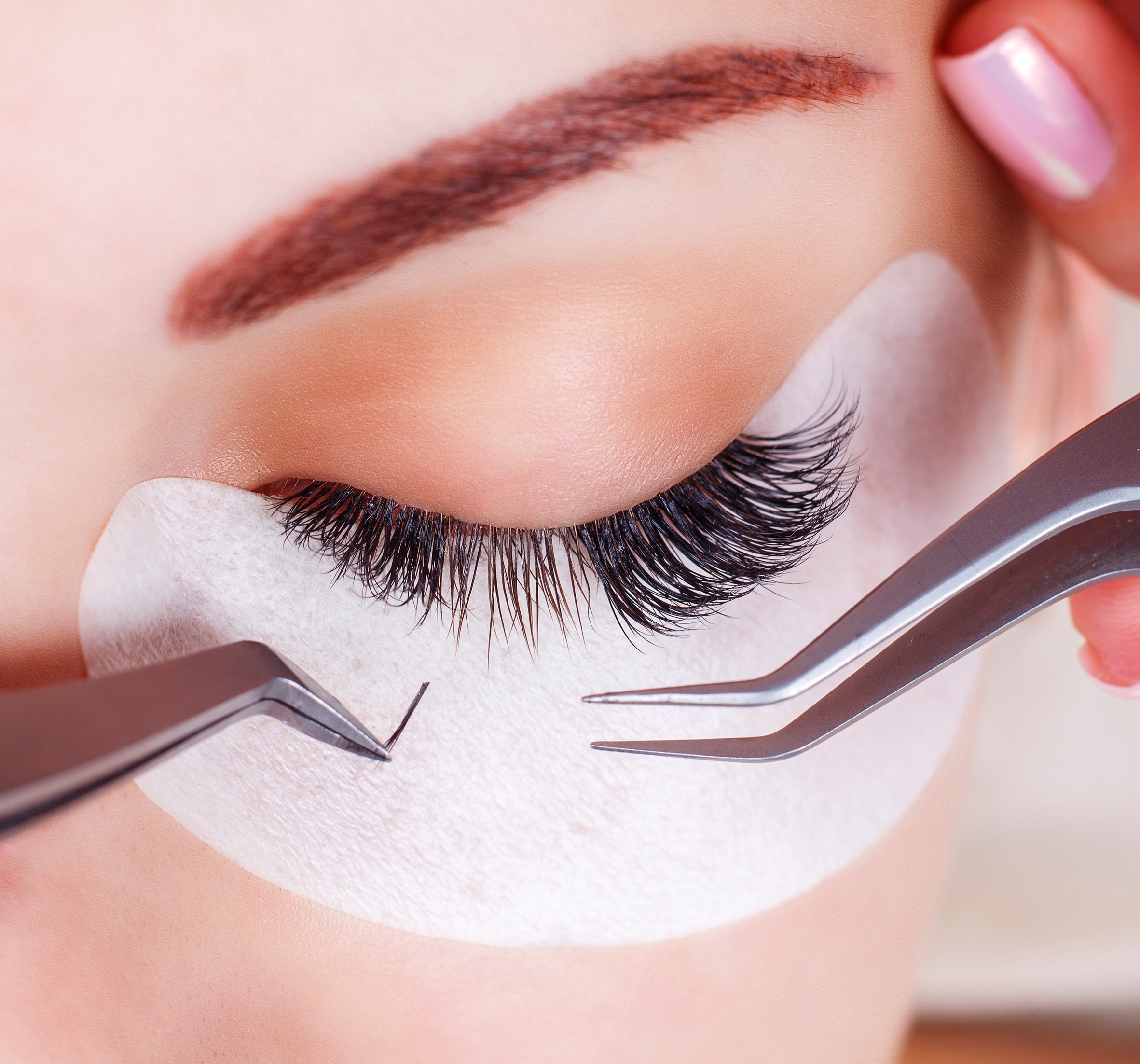 a closeup of the eye while applying lash extensions