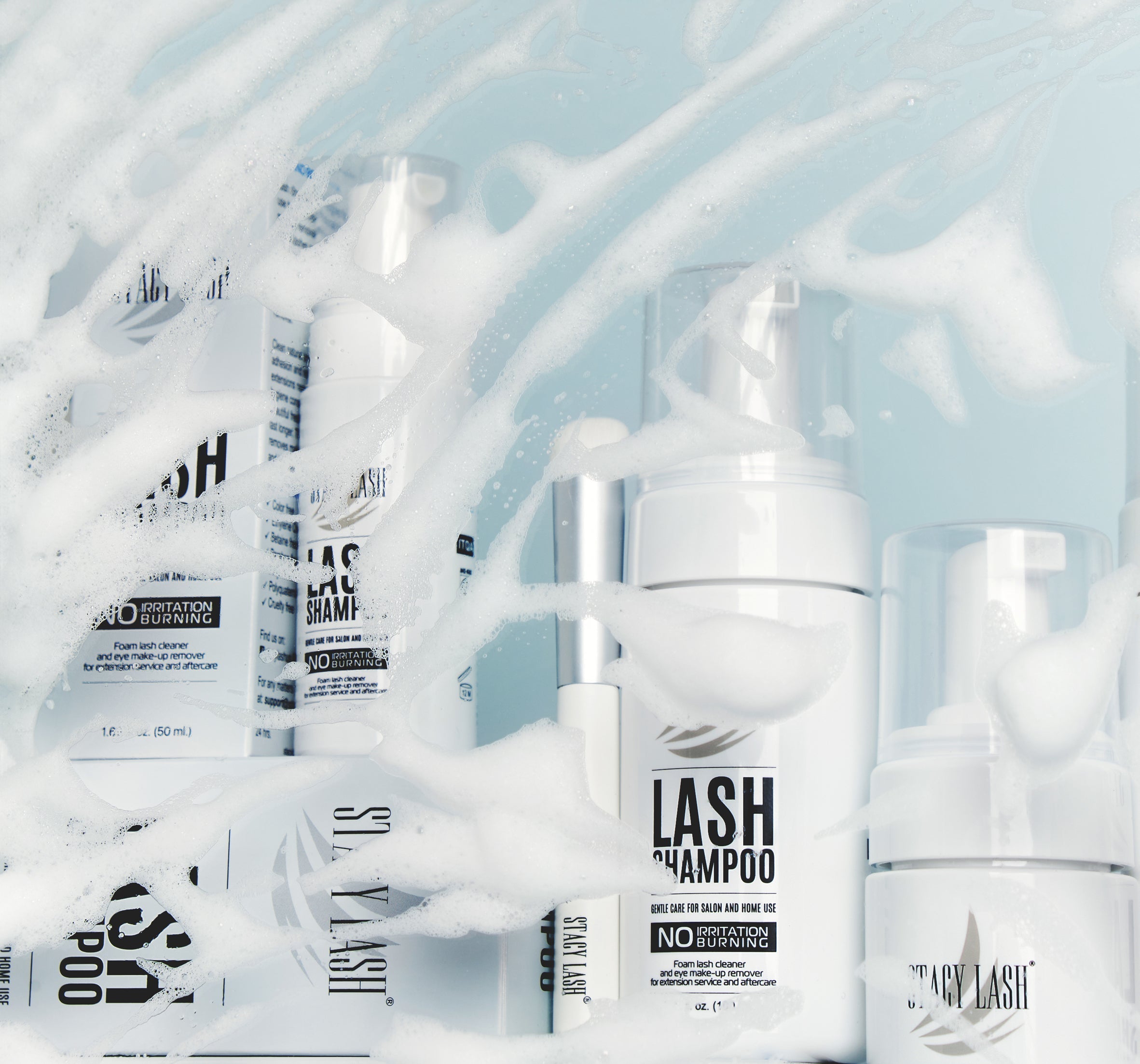 several bottles of lash extension shampoo covered in foam