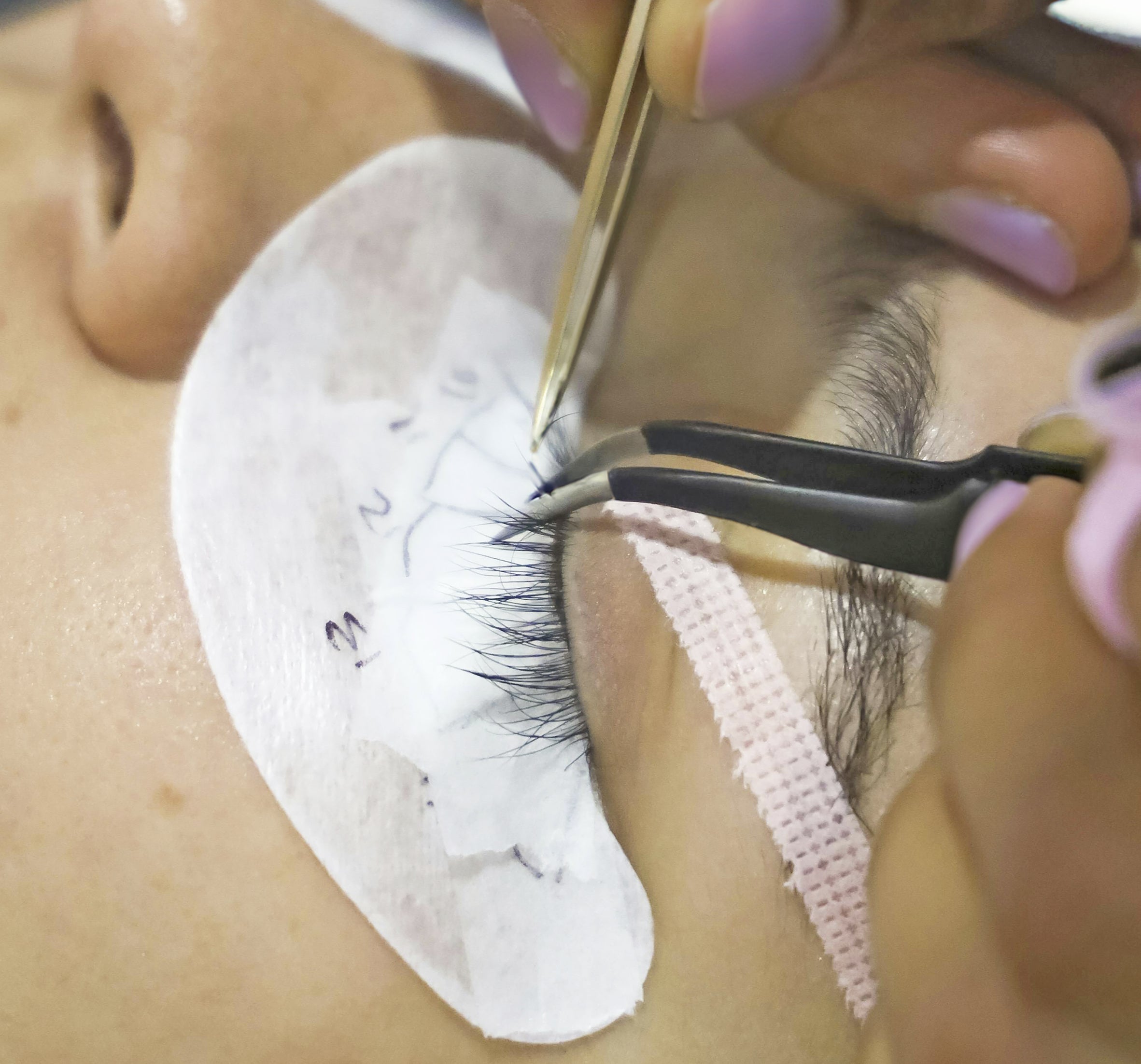 Professional lash artist applying eyelash extensions